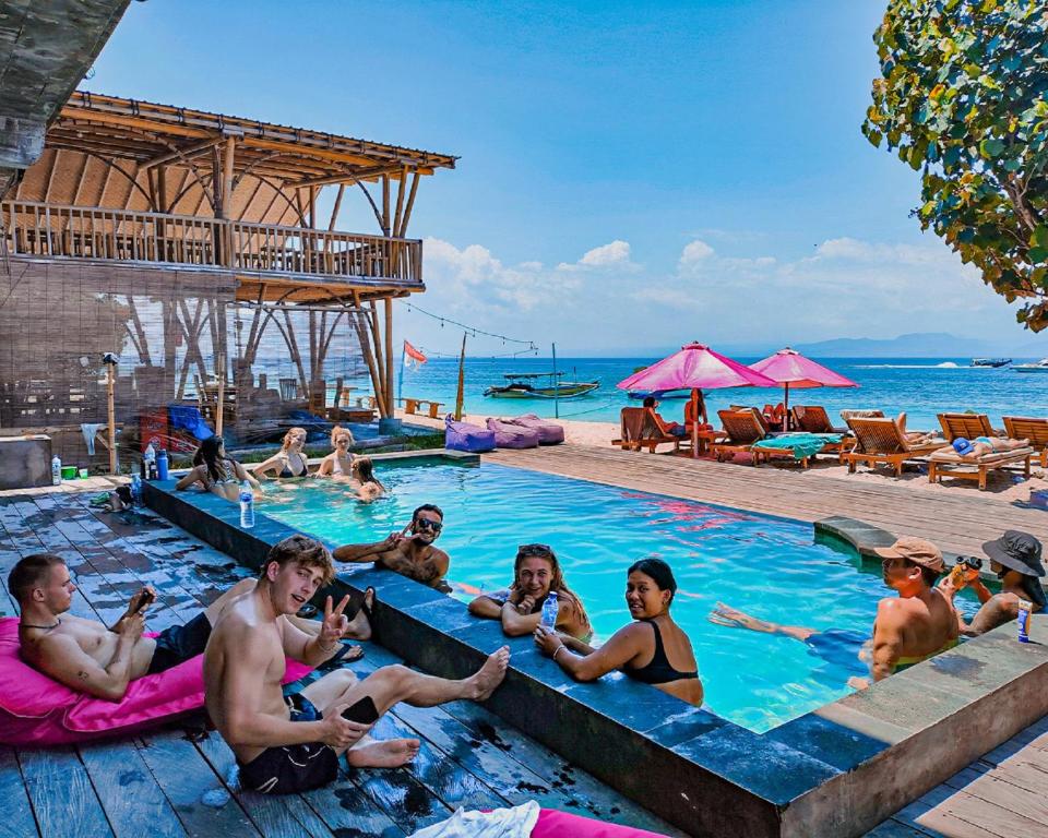 eine Gruppe von Menschen sitzt in einem Schwimmbecken in der Unterkunft Lushy Hostel Nusa Penida in Nusa Penida