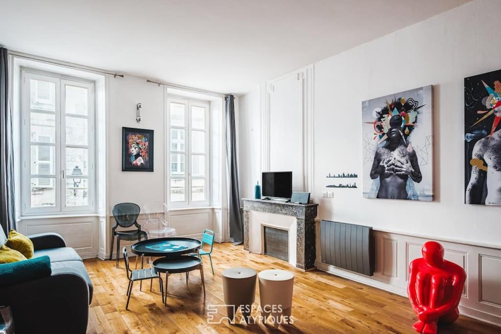 un salon avec un canapé et une cheminée dans l'établissement Appartement de charme en centre-ville de La Rochelle, à La Rochelle