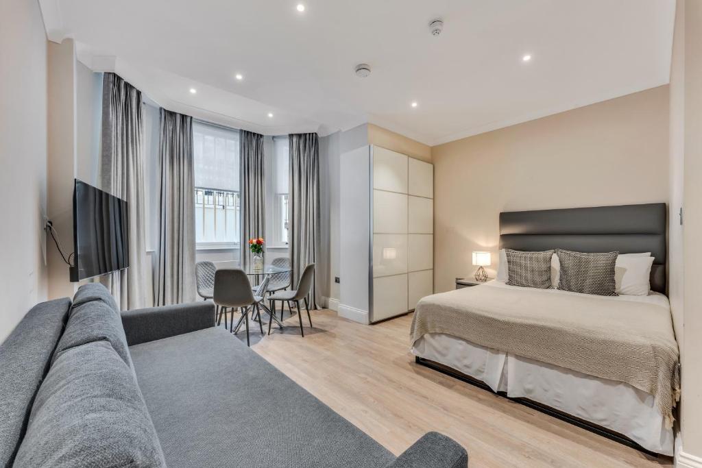 ein Hotelzimmer mit einem Bett und einer Couch in der Unterkunft Cleveland Residences Chelsea in London