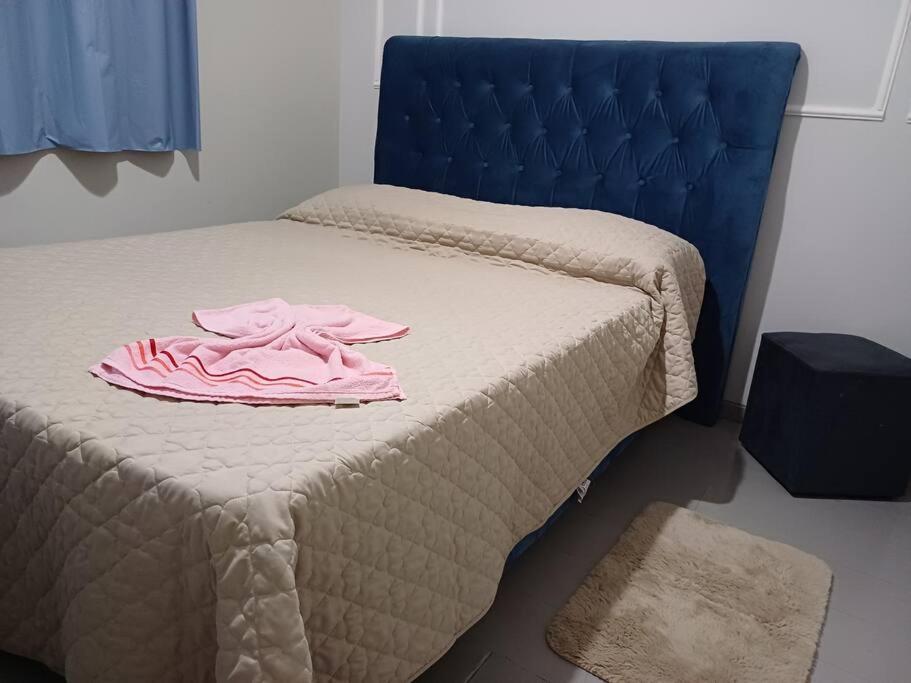a pink shirt on a bed in a room at apto simples,3min centro, 3 min da Unimed com wifi in Araçatuba