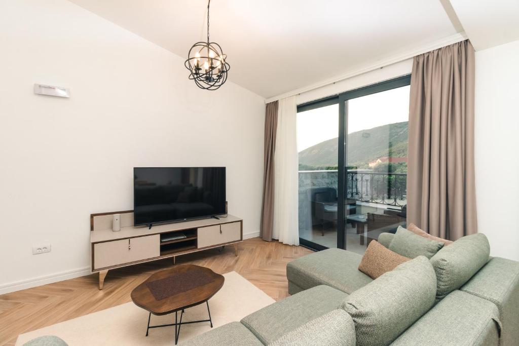 a living room with a couch and a tv at CAROLEA VILLAS in Ulcinj