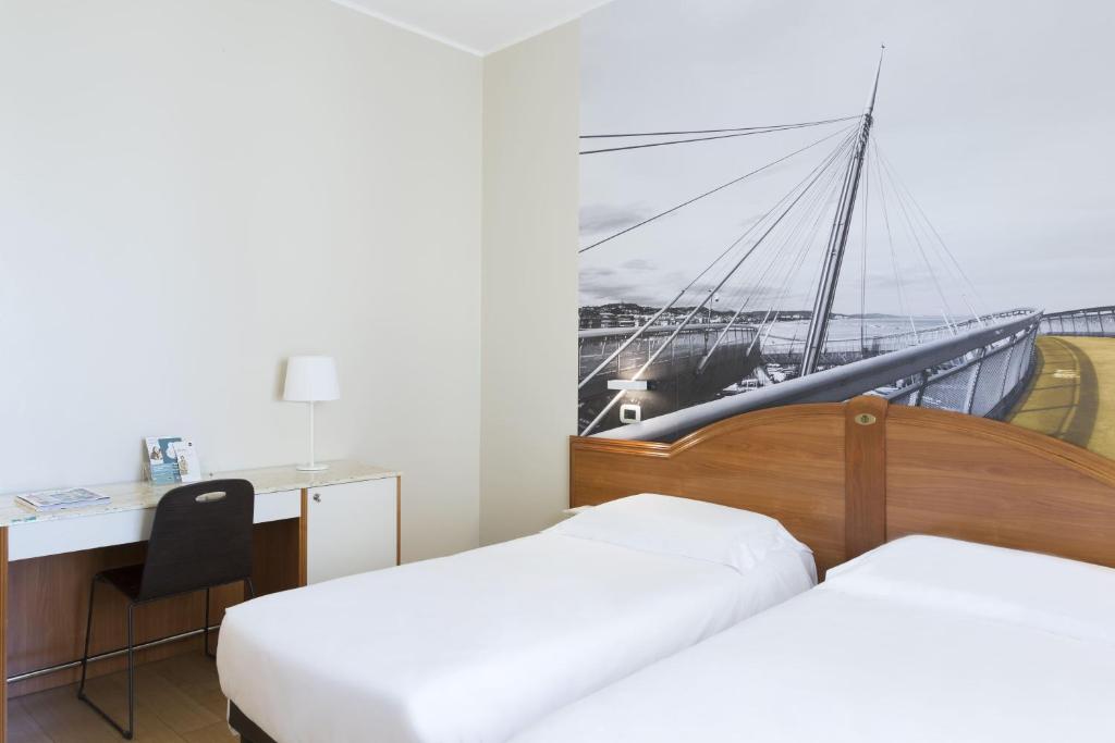 a hotel room with two beds and a desk and a boat at B&B Hotel Pescara in Pescara