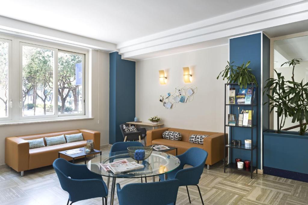 a waiting room with a couch and a table and chairs at B&B Hotel Pescara in Pescara