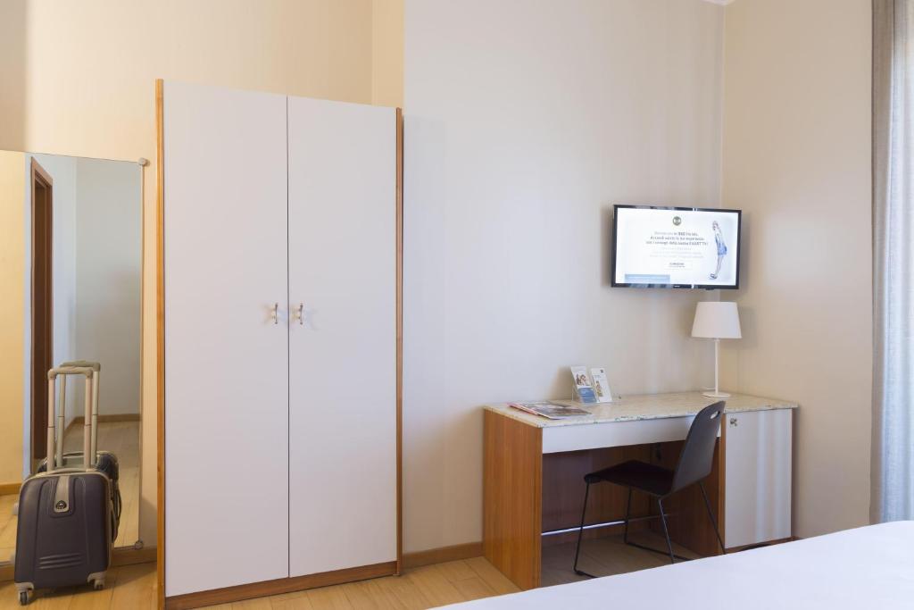 a bedroom with a desk and a large white closet at B&B Hotel Pescara in Pescara