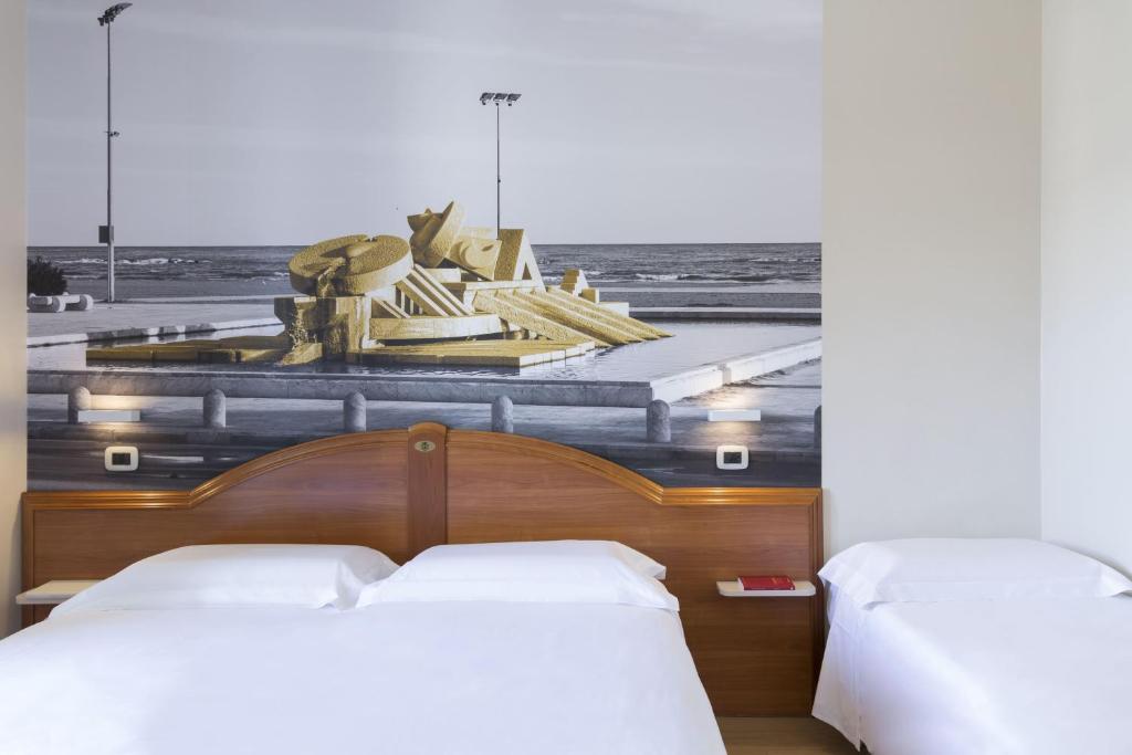 a bedroom with two beds and a painting of the ocean at B&B Hotel Pescara in Pescara