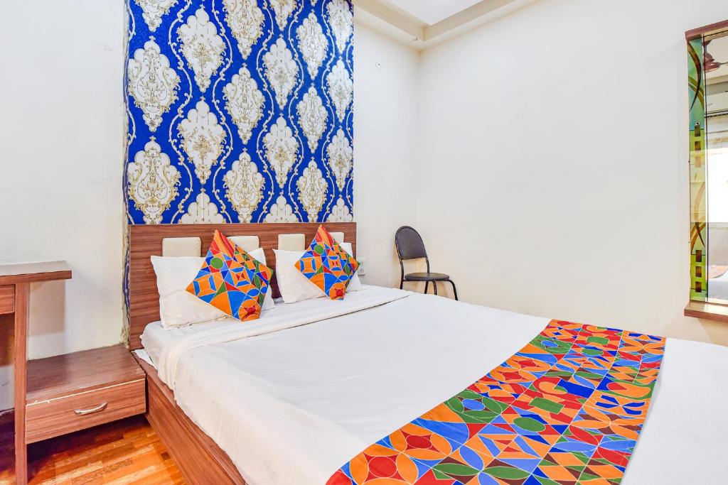 Un dormitorio con una cama grande con almohadas de colores. en FabHotel Shri Shyam Palace, en Ujjain