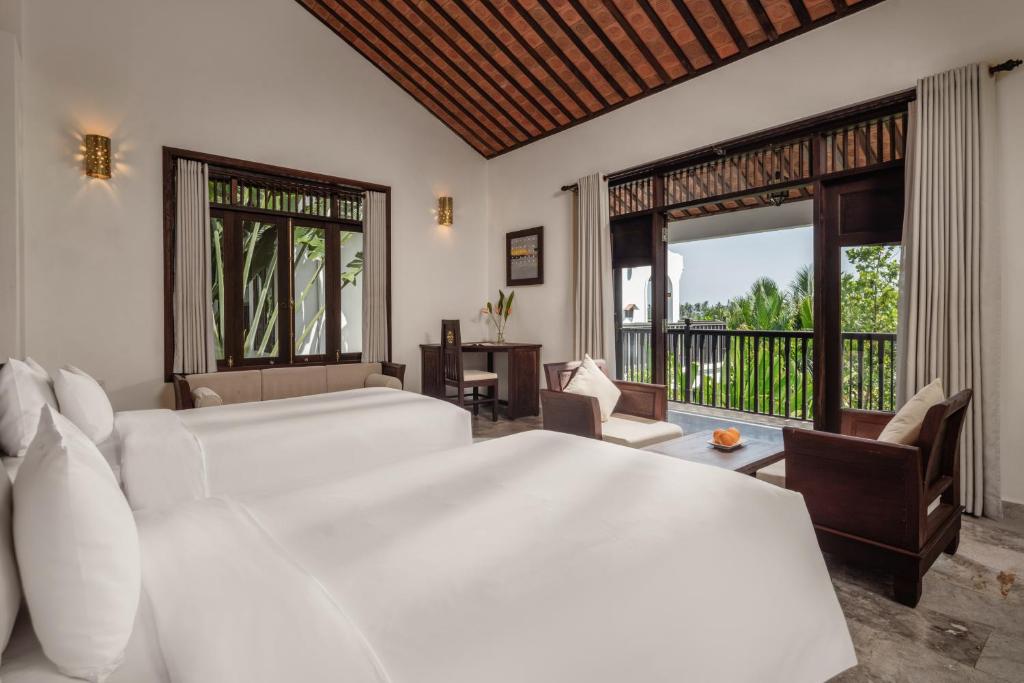 Postel nebo postele na pokoji v ubytování Legacy Hoi An Resort