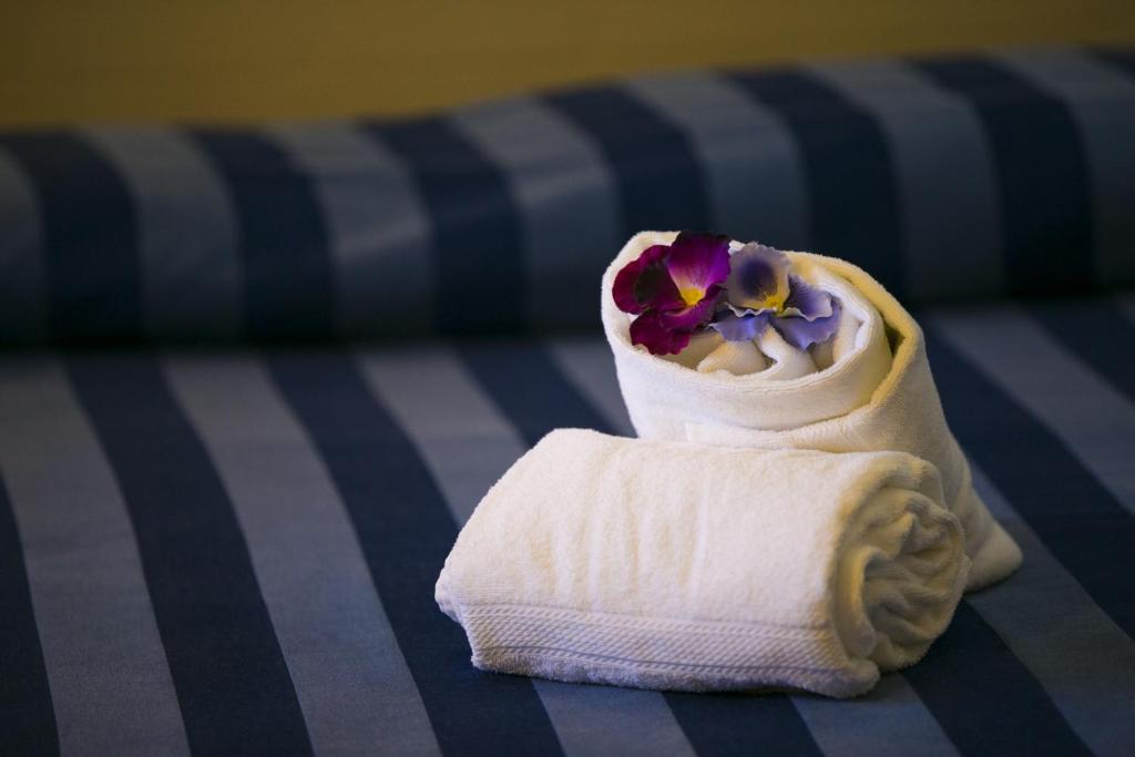 zwinięty ręcznik z kwiatem w obiekcie Trigrana Vacanze Hotel w mieście Castelluzzo