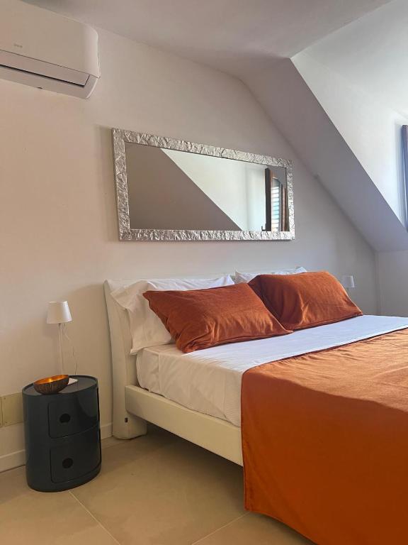 a bedroom with a bed with a mirror on the wall at Domus Orestea Luxury Suites in Palermo