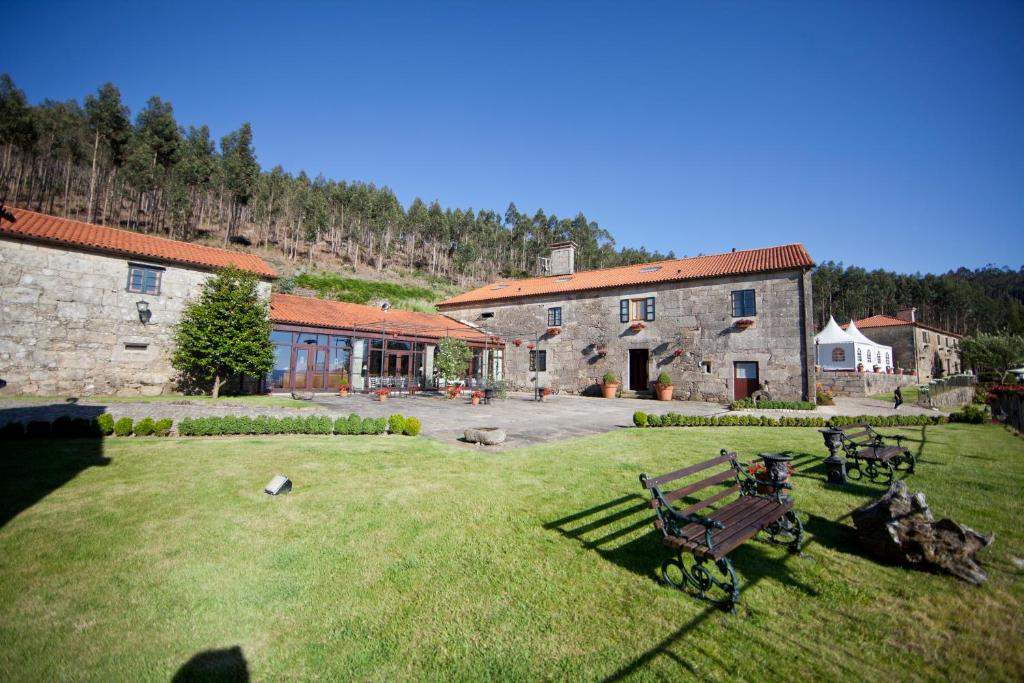 a large yard with benches in front of a building at Casa Grande Do Bachao in Santiago de Compostela
