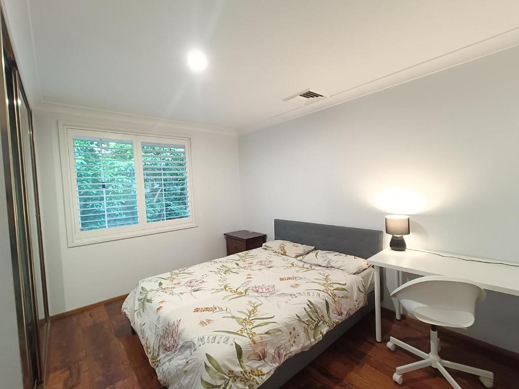 a bedroom with a bed and a desk and a window at Cozy Room in Modern and Peaceful Home - BH5 in Baulkham Hills