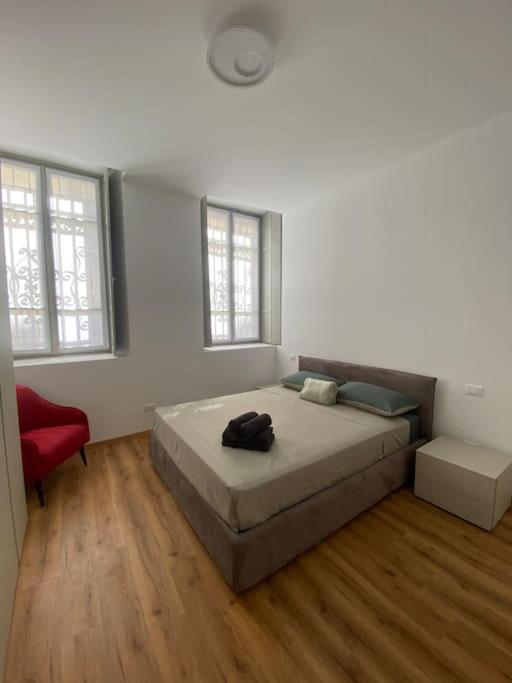 a bedroom with a bed and a red chair at Bilocale centro storico in Novara