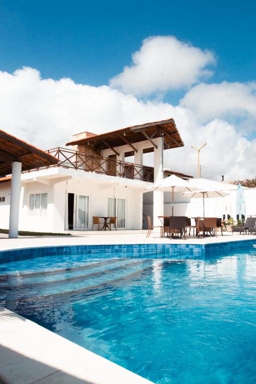 a swimming pool in front of a villa at Casa La Baule in Aquiraz