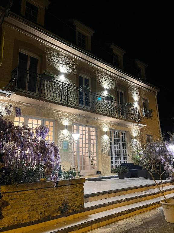 a building with a balcony and flowers in front of it at Logis Hôtel Restaurant Le Lascaux in Montignac