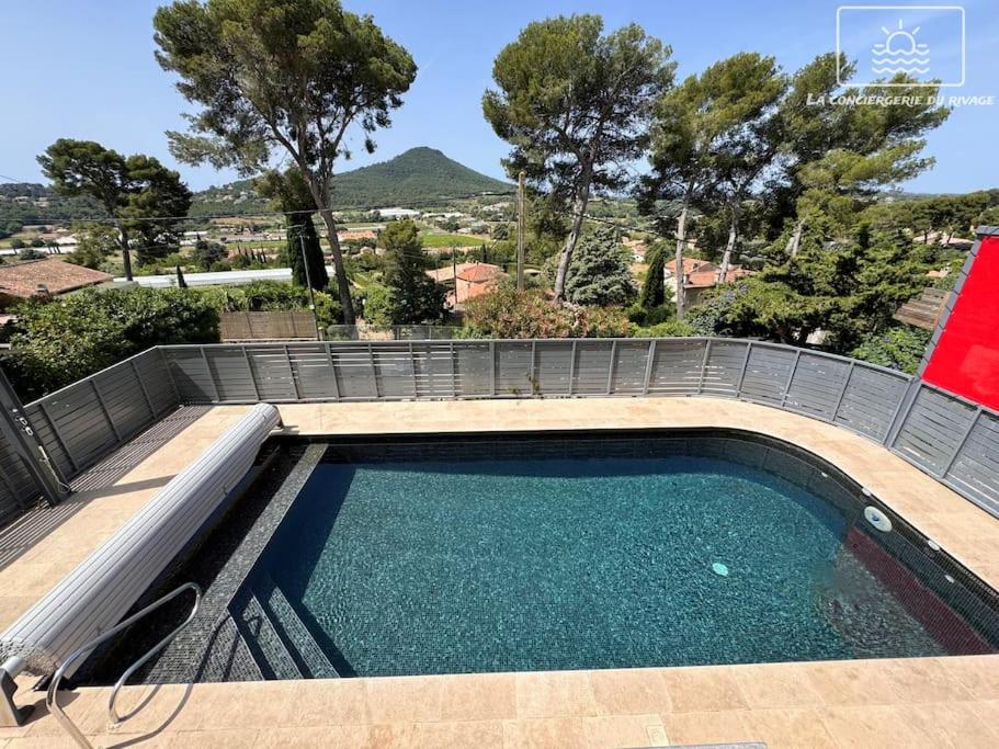 a swimming pool in a backyard with a patio at La Gacélyte Piscine privée joli bas de villa in Carqueiranne