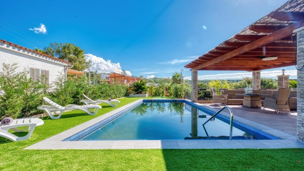 a swimming pool in the yard of a house at Costacabana - Villa Palmera in Lloret de Mar