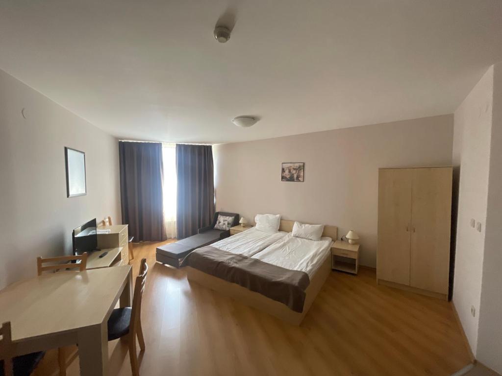 une chambre avec un lit, une table et un bureau dans l'établissement Aspen Golf and Ski Resort, à Bansko
