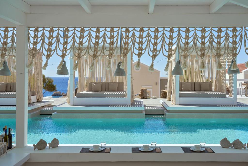 a room with a swimming pool with blue water at Althea Boutique Hotel - Adults Only in Amoopi