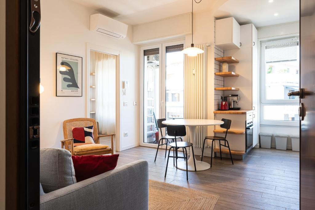 a living room with a table and chairs at Moderno bilocale sui Navigli - Mirable PM in Milan