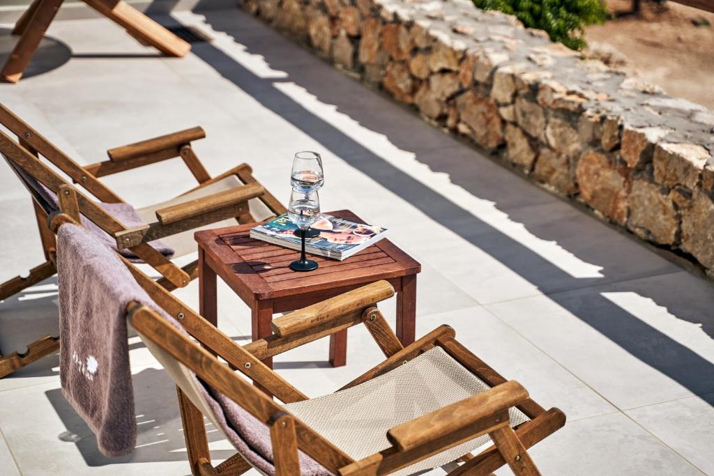 a table and chairs with a wine glass on it at Althea Boutique Hotel - Adults Only in Amoopi