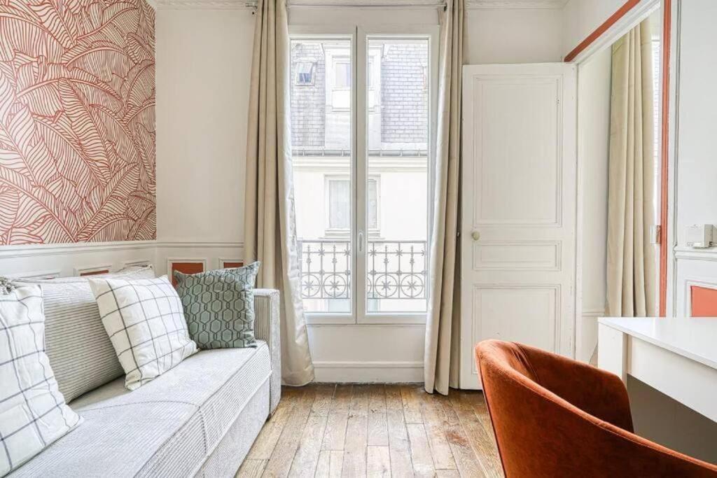 un salon avec un canapé et une fenêtre dans l'établissement Green apartment Paris city center - V, à Paris