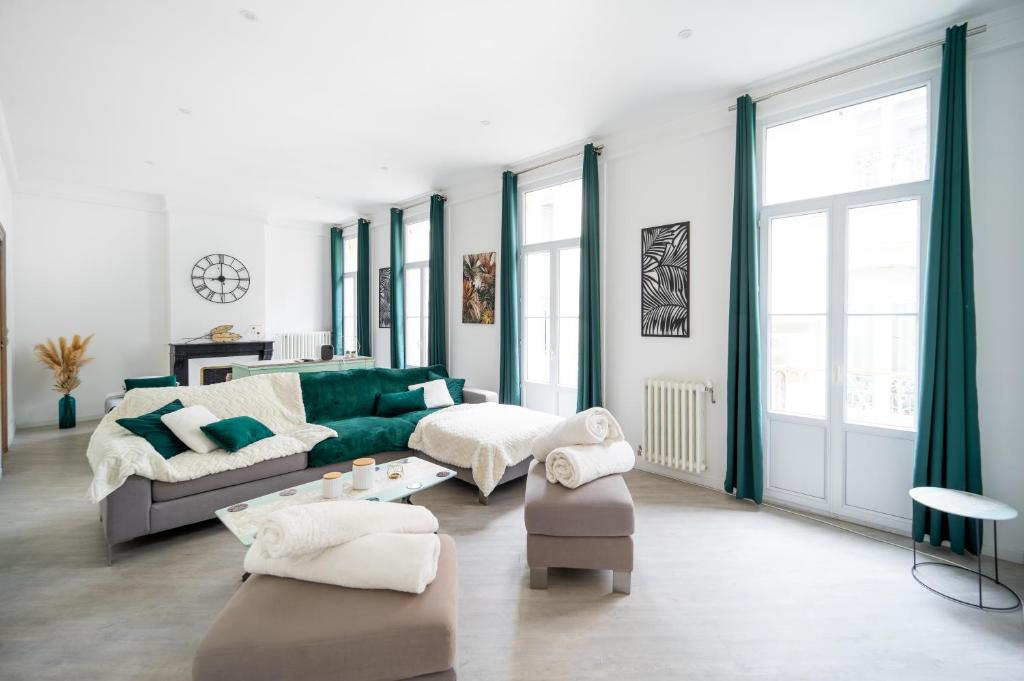 un salon avec un canapé vert et des chaises dans l'établissement L'émeraude - Centre, Spacieux & Tout équipé, à Montpellier