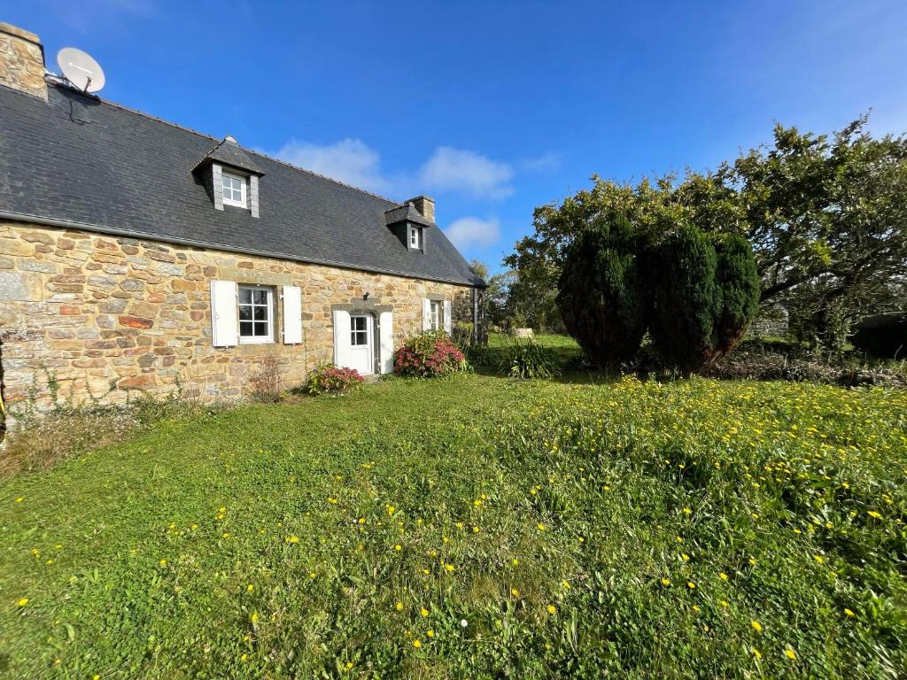 une ancienne maison en pierre avec une cour herbeuse dans l'établissement Penty Kael, à Crozon