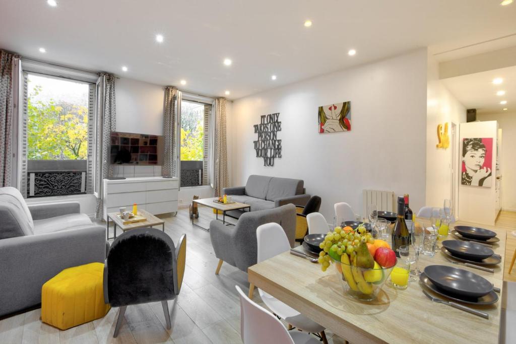 un salon avec une table et une salle à manger dans l'établissement Bluestay 149 - Spacieux appartement Paris centre, à Paris