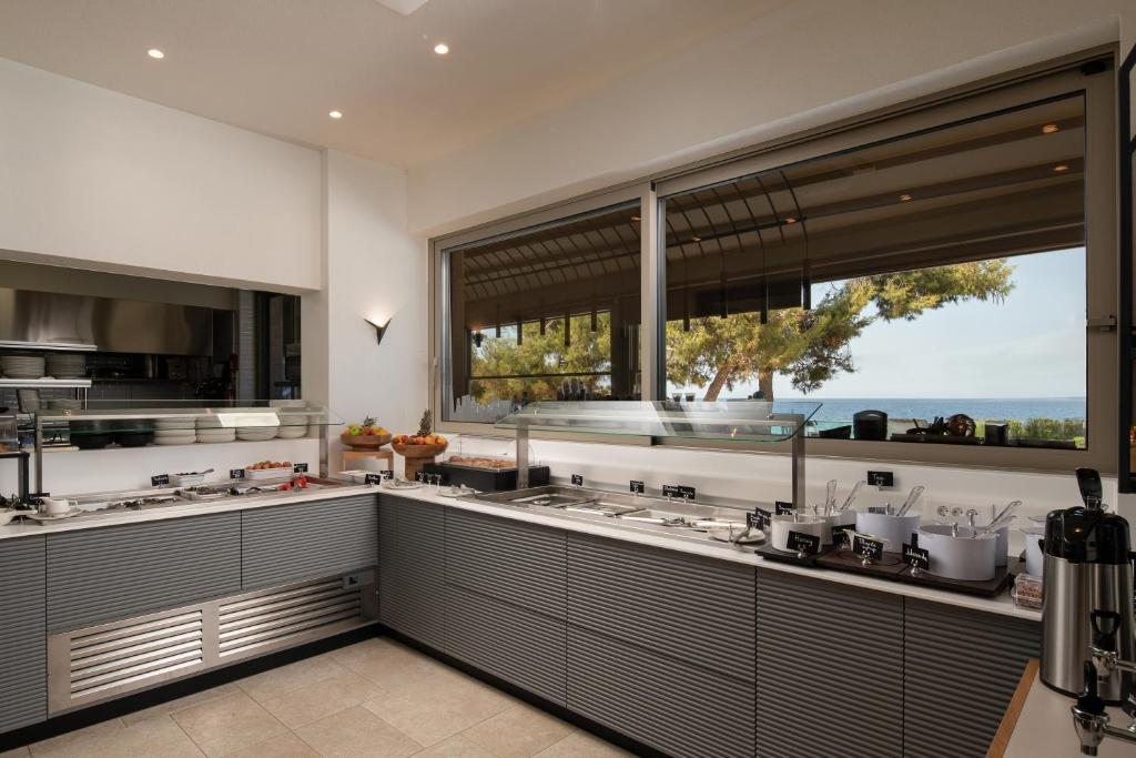 a kitchen with two sinks and a large window at Oniro Boutique Hotel in Toroni