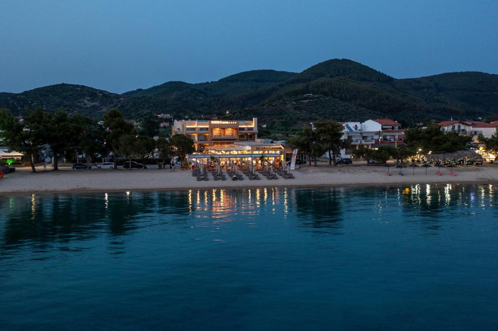 a building on a beach at night with the water at Oniro Boutique Hotel in Toroni
