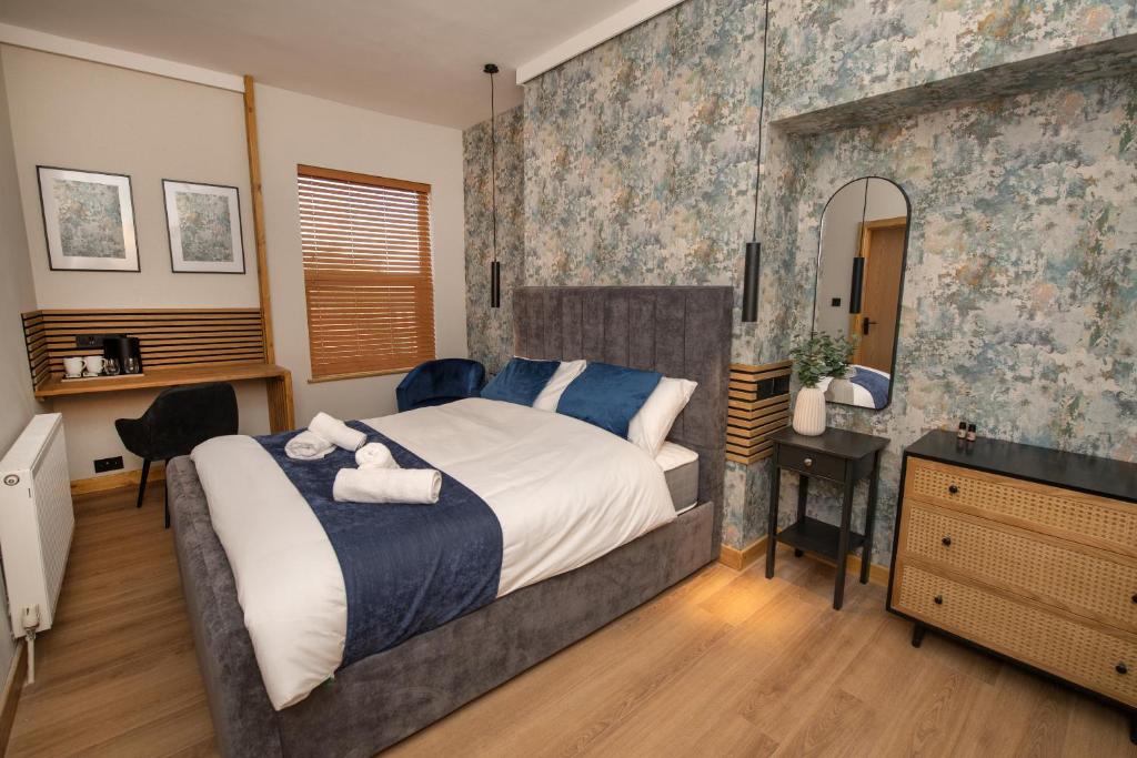 a bedroom with a bed and a desk and a mirror at Amber Hotel in Hull