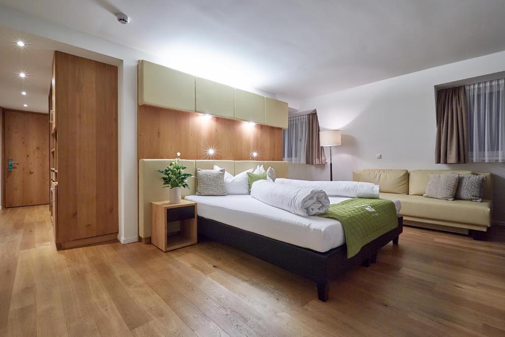 ein großes Schlafzimmer mit einem großen Bett und einem Sofa in der Unterkunft m3Hotel in Sankt Anton am Arlberg