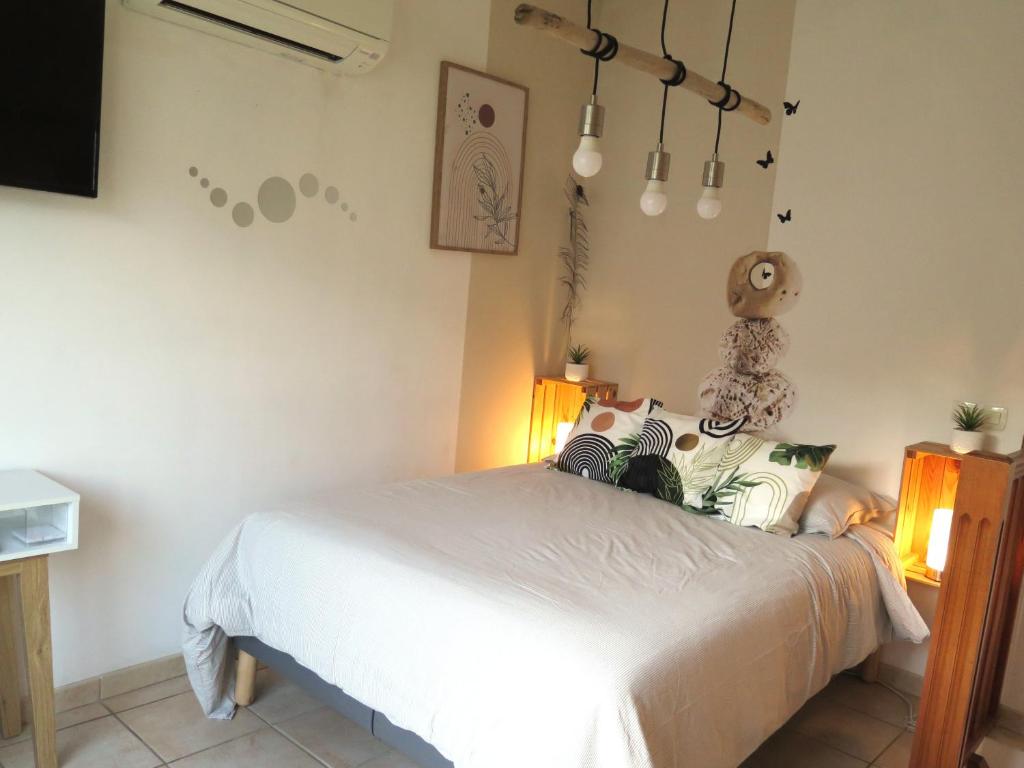 a bedroom with a white bed and a tv at Maison de village à 35 m du bord de mer in Marseille