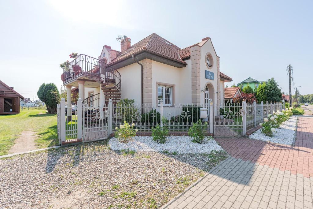 una casa con una recinzione bianca davanti di Pensjonat Kwiatkowski apartament nr 3 a Nowęcin