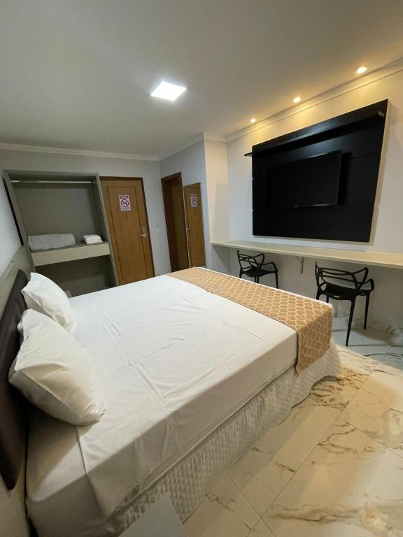a bedroom with a bed and a flat screen tv at Hotel Uipi in Sorriso