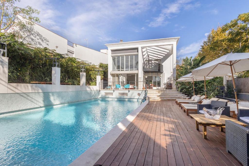 una piscina con bancos y una casa en Villa Cela, en Masnou