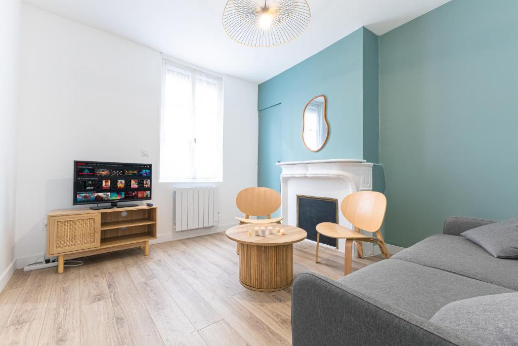 a living room with a couch and a tv at La Mancelle - 6 Personnes - Plein cœur du Mans in Le Mans