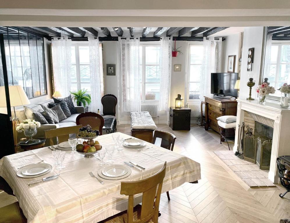 un salon avec une table et un salon avec une cheminée dans l'établissement Nid douillet au cœur de Paris, à Paris