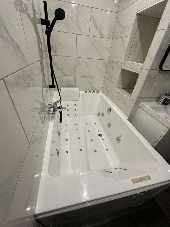 La salle de bains est pourvue d'une baignoire blanche. dans l'établissement STUDIO JACCUZZI A 2 Min dAvignon, aux Angles (Gard)