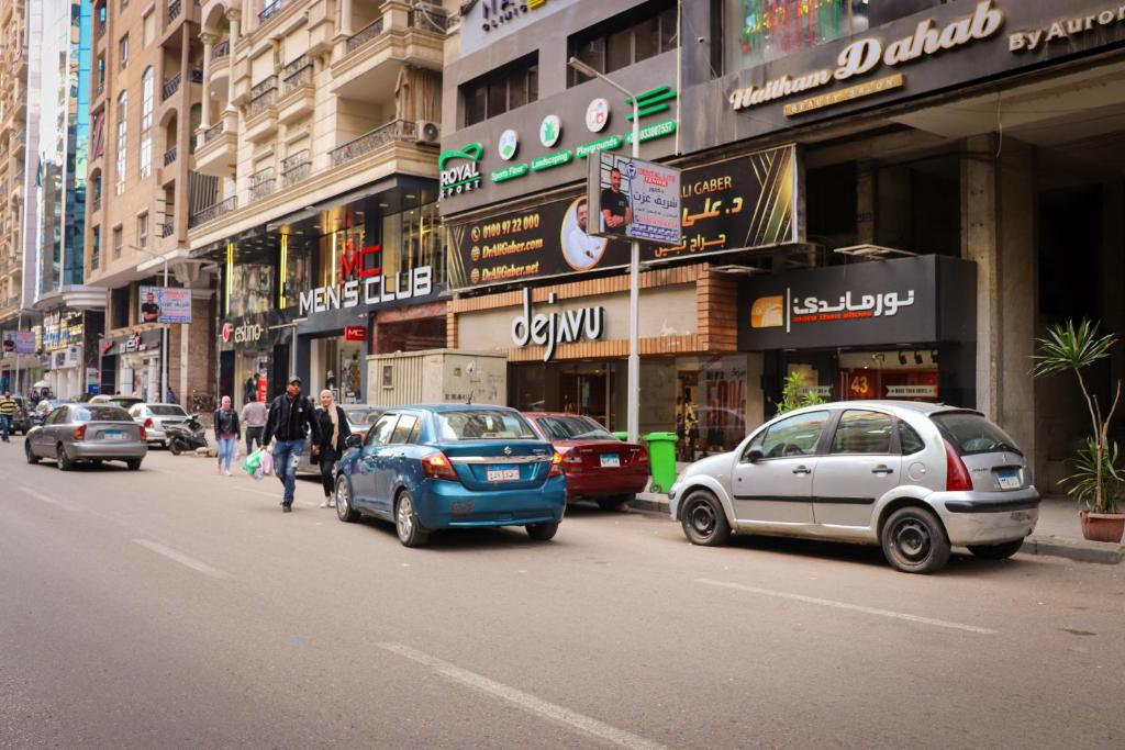 a busy city street with cars parked in front of buildings at المهندسين شقه سوبر لوكس - محى الدين ابو العز in Cairo