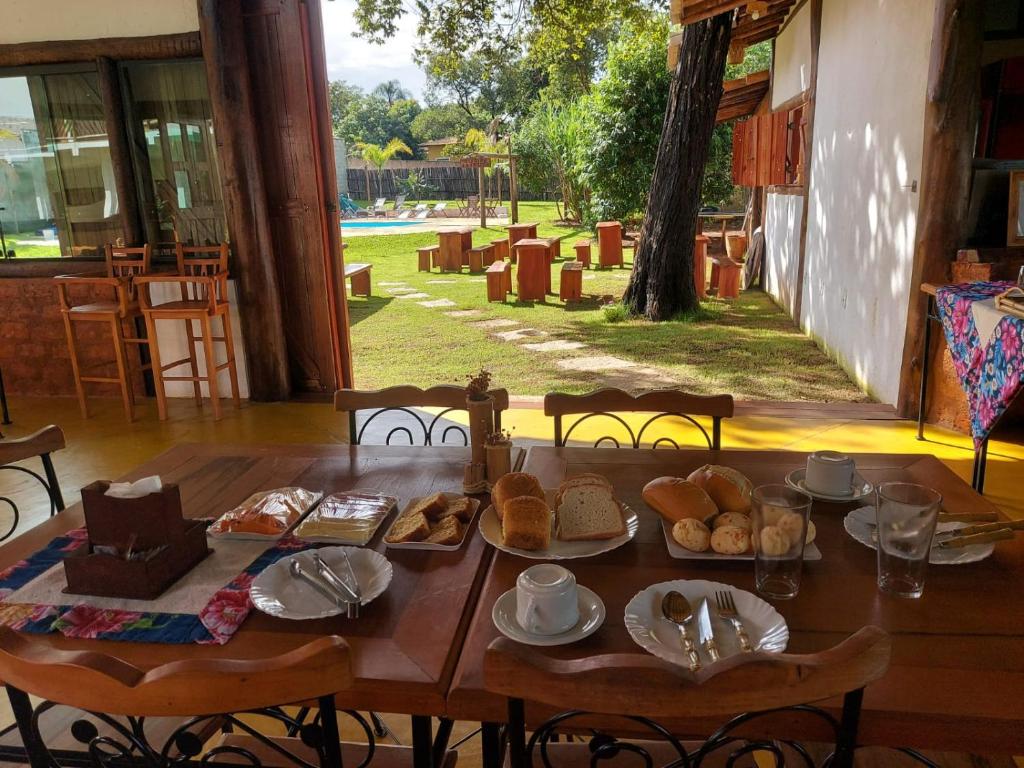 a wooden table with bread and pastries on it at Pousada Real Cipo in Serra do Cipo