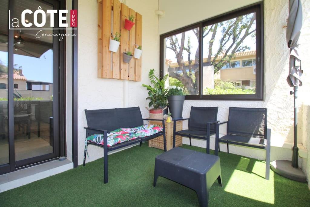 d'une terrasse avec 3 chaises, un banc et une fenêtre. dans l'établissement rive d'or bgv, à Sausset-les-Pins