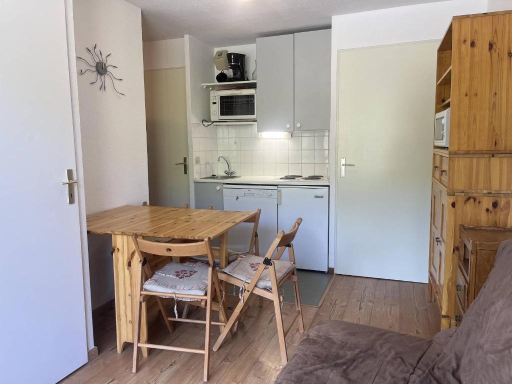 une petite cuisine avec une table et des chaises dans une pièce dans l'établissement Plagne Soleil: Appartement 2 pièces avec balcon, accès direct pistes, centre proche commerces - FR-1-351-14, à Plagne Villages