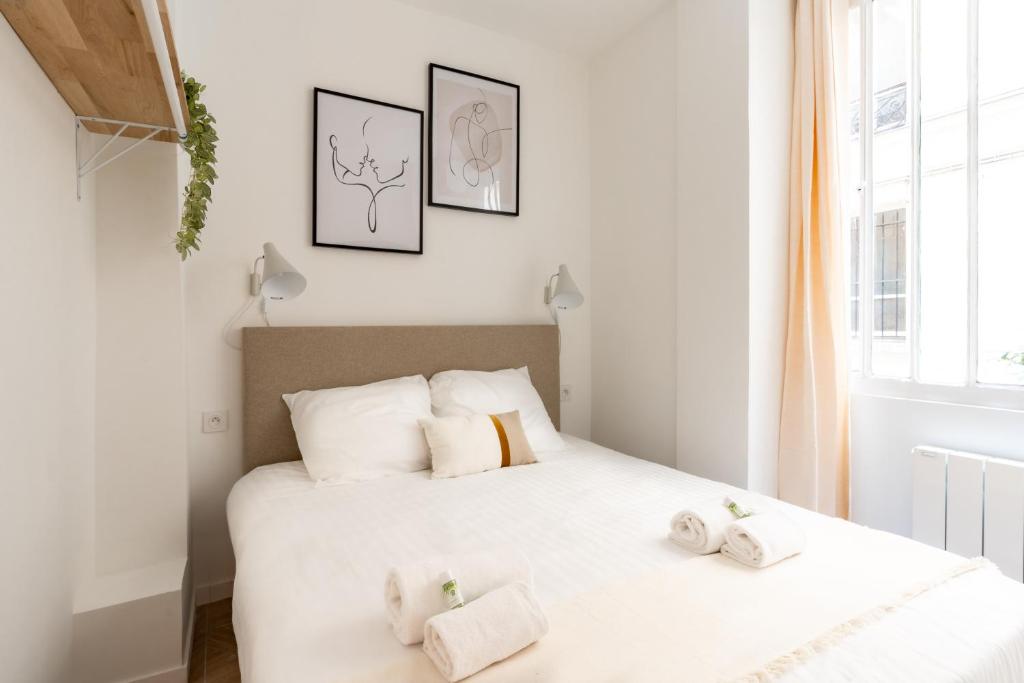 une chambre avec deux lits avec des serviettes dessus dans l'établissement Calm and cozy flat - Central location, à Paris