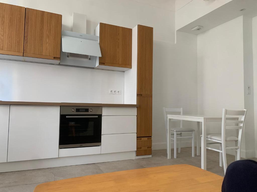 une cuisine avec des armoires blanches et une table avec des chaises dans l'établissement Cœur du Prado À deux, pas des Plage et du stade plein centre, à Marseille