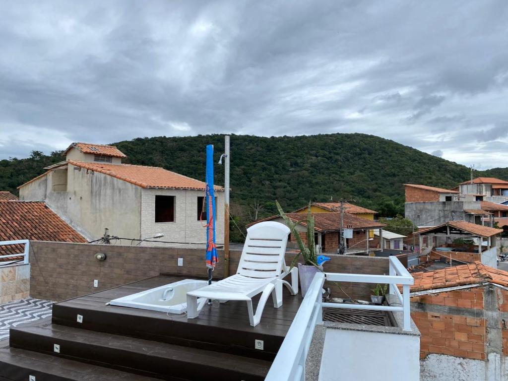 a white chair sitting on top of a roof at Aconchego do peró in Cabo Frio