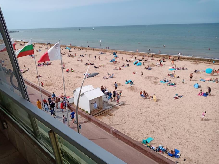 Une foule de gens sur une plage avec l'océan dans l'établissement La Lagure, à Courseulles-sur-Mer