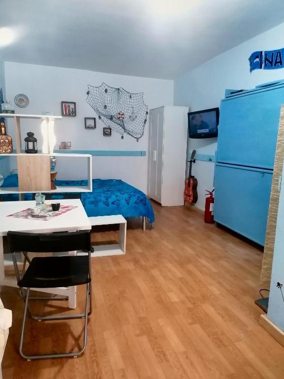 Pokój z łóżkiem, stołem i lodówką w obiekcie Salotto Mergellina w mieście Neapol