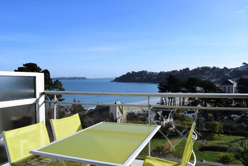 une table et des chaises sur un balcon avec vue sur l'océan dans l'établissement Appartement 2-4 pers VUE MER EXCEPTIONNELLE avec terrasse à PERROS-GUIREC - Ref 908, à Perros-Guirec