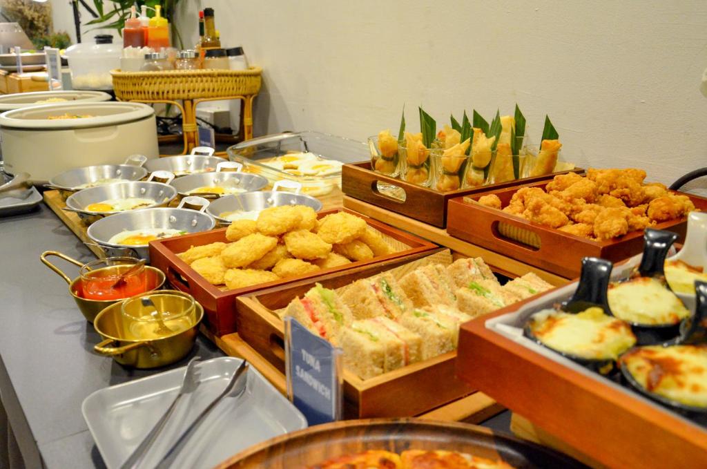 A buffet table presents hot dishes, sandwiches, fruit and sauces.